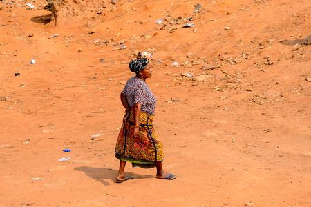 ELMINA, GHANA -JAN 18, 2017: Unidentified  Ghanaian woman walks on the street in Elmina. People of Ghana suffer of poverty due to the bad economyのeditorial素材