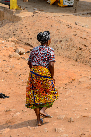 ELMINA, GHANA -JAN 18, 2017: Unidentified  Ghanaian woman walks on the street in Elmina. People of Ghana suffer of poverty due to the bad economyのeditorial素材