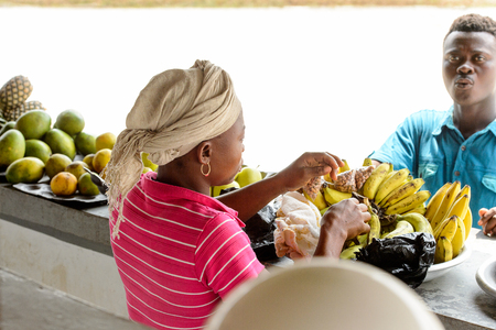 CENTRAL REGION, GHANA - Jan 17, 2017: Unidentified Ghanaian woman sells fruits in local village. People of Ghana suffer of poverty due to the bad economyのeditorial素材
