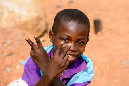 ELMINA, GHANA -JAN 18, 2017: Unidentified  Ghanaian little boy in purple shirt smiles in Elmina. Children of Ghana suffer of poverty due to the bad economyのeditorial素材