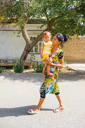 BUKHARA, UZBEKISTAN - JUNE 7, 2011: Unidentified Uzbek woman goes for a walk with her child Uzbekistan, Jun 7, 2011.  81% of people in Uzbekistan belong to Uzbek ethnic groupのeditorial素材