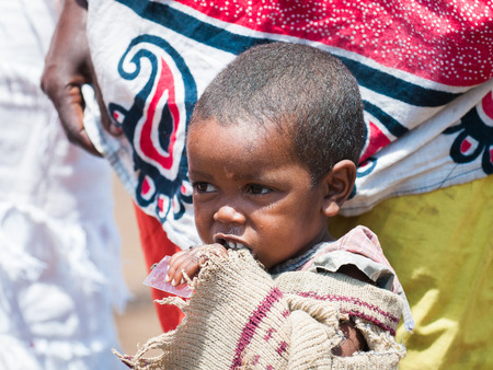 AMBOSELI, KENYA - OCTOBER 10, 2009: Unidentified Massai little shy baby girl portrait in old clothes in Kenya, Oct 10, 2009. Massai people are a Nilotic ethnic groupのeditorial素材
