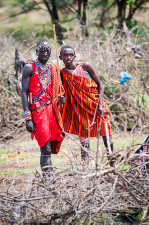 AMBOSELI, KENYA - OCTOBER 10, 2009: Unidentified Massai husband and wife waving and smiling for the camera in Kenya, Oct 10, 2009. Massai people are a Nilotic ethnic groupのeditorial素材