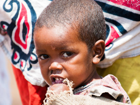 AMBOSELI, KENYA - OCTOBER 10, 2009: Unidentified Massai little shy baby girl portrait in old clothes in Kenya, Oct 10, 2009. Massai people are a Nilotic ethnic groupのeditorial素材
