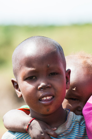 AMBOSELI, KENYA - OCTOBER 10, 2009: Portait of an unidentified Massai little boy wearing a pink sheet in Kenya, Oct 10, 2009. Massai people are a Nilotic ethnic groupのeditorial素材