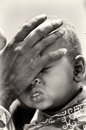 KENYA - OCTOBER 10, 2009: Unidentified Massai woman touches her baby's face in Kenya, Oct 10, 2009. Massai people are a Nilotic ethnic groupのeditorial素材