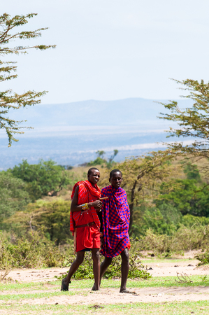 AMBOSELI, KENYA - OCTOBER 10, 2009: Two unidentified Massai people walk and talk in Kenya, Oct 10, 2009. Massai people are a Nilotic ethnic groupのeditorial素材
