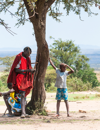 AMBOSELI, KENYA - OCTOBER 10, 2009: Unidentified Massai people near the tree in Kenya, Oct 10, 2009. Massai people are a Nilotic ethnic groupのeditorial素材