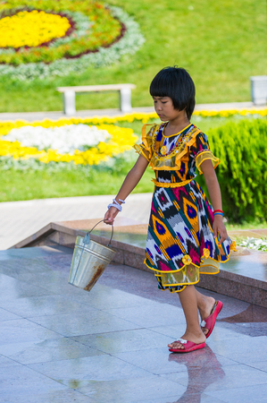 TASHKENT, UZBEKISTAN - JUNE 12, 2011: Unidentified Uzbek girl cleans the floor in Uzbekistan, Jun 12, 2011.  81% of people in Uzbekistan belong to Uzbek ethnic groupのeditorial素材