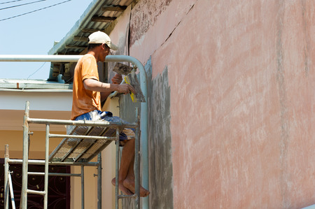 TASHKENT, UZBEKISTAN - JUNE 12, 2011: Unidentified Uzbek man put the paint on the wall in Uzbekistan, Jun 12, 2011.  81% of people in Uzbekistan belong to Uzbek ethnic groupのeditorial素材