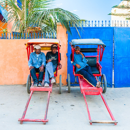 ANTANANARIVO, MADAGASCAR - JUNE 27, 2011: Unidentified Madagascar people sit in a transport carriage. People in Madagascar suffer of poverty due to the slow development of the countryのeditorial素材