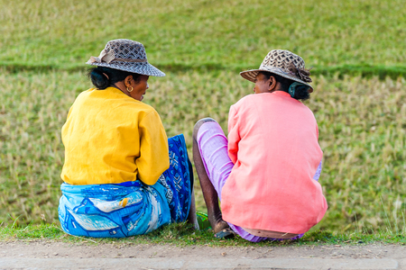 ANTANANARIVO, MADAGASCAR - JUNE 30, 2011: Unidentified Madagascar women in hats sit and discuss on the ground. People in Madagascar suffer of poverty due to the slow development of the countryのeditorial素材