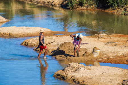 ANTANANARIVO, MADAGASCAR - JUNE 29, 2011: Unidentified Madagascar women fill the bags with sand. People in Madagascar suffer of poverty due to the slow development of the countryのeditorial素材