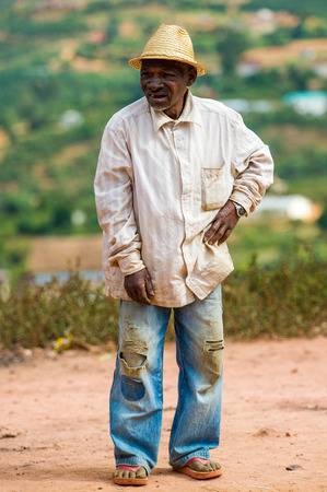 ANTANANARIVO, MADAGASCAR - JUNE 30, 2011: Unidentified Madagascar man in hat and white shirt stays and smiles. People in Madagascar suffer of poverty due to the slow development of the countryのeditorial素材