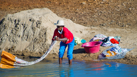 ANTANANARIVO, MADAGASCAR - JUNE 29, 2011: Unidentified Madagascar woman washes and cleans a sheet. People in Madagascar suffer of poverty due to the slow development of the countryのeditorial素材