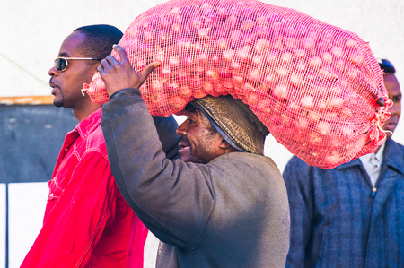 ANTANANARIVO, MADAGASCAR - JUNE 27, 2011: Unidentified Madagascar man carries huge bag of garlic. People in Madagascar suffer of poverty due to the slow development of the countryのeditorial素材