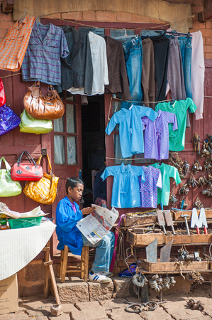ANTANANARIVO, MADAGASCAR - JUNE 30, 2011: Unidentified Madagascar sell clothes and reas paper at the market. People in Madagascar suffer of poverty due to the slow development of the countryのeditorial素材