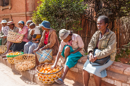 ANTANANARIVO, MADAGASCAR - JUNE 30, 2011: Unidentified Madagascar women sell apples and other fruits at the market. People in Madagascar suffer of poverty due to the slow development of the countryのeditorial素材
