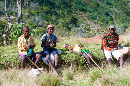 ANTANANARIVO, MADAGASCAR - JUNE 30, 2011: Unidentified Madagascar people  with wooden sticks in the street. People in Madagascar suffer of poverty due to slow development of the countryのeditorial素材