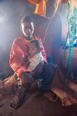 ANTANANARIVO, MADAGASCAR - JUNE 30, 2011: Unidentified Madagascarfather plays with his son in a house. People in Madagascar suffer of poverty due to slow development of the countryのeditorial素材