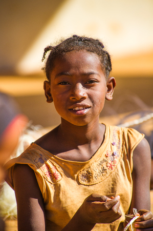 MADAGASCAR - JULY 1, 2011: Portrait of an unidentified girl wearing a yellow dress in Madagascar, July 1, 2011. People of Madagascar suffer of poverty due to the unstable situation.のeditorial素材