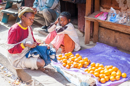 ANTANANARIVO, MADAGASCAR - JUNE 30, 2011: Unidentified Madagascar girl sells oranges at the market. People in Madagascar suffer of poverty due to slow development of the countryのeditorial素材