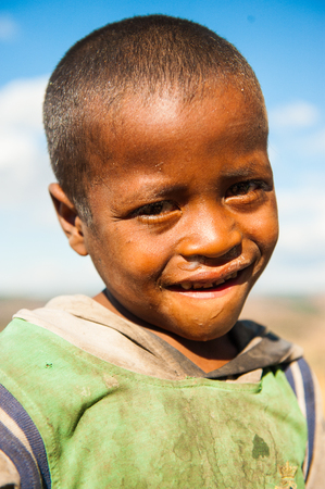 MADAGASCAR - JUNE 30, 2011: Portrait of an unidentified smiling little boy in Madagascar, June 30, 2011. People of Madagascar suffer of poverty due to the unstable situation.のeditorial素材