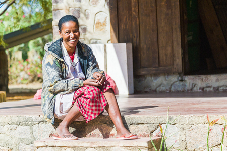 ANTANANARIVO, MADAGASCAR - JULY 2, 2011: Unidentified Madagascar woman smiles on a porch of a house. People in Madagascar suffer of poverty due to slow development of the countryのeditorial素材