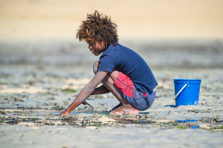 ANTANANARIVO, MADAGASCAR - JULY 3, 2011: Unidentified Madagascar boy plays with sand. People in Madagascar suffer of poverty due to slow development of the countryのeditorial素材