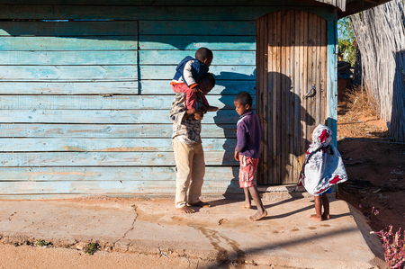 ANTANANARIVO, MADAGASCAR - JULY 3, 2011: Unidentified Madagascar father and his children in the street. People in Madagascar suffer of poverty due to slow development of the countryのeditorial素材