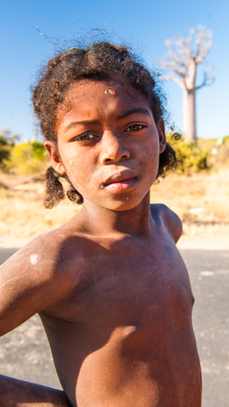 ANTANANARIVO, MADAGASCAR - JULY 3, 2011: Unidentified Madagascar boy runs near a road. People in Madagascar suffer of poverty due to slow development of the countryのeditorial素材