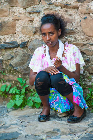 OMO, ETHIOPIA - SEPTEMBER 20, 2011: Unidentified Ethiopian girl sits near a stome wall. People in Ethiopia suffer of poverty due to the unstable situationのeditorial素材