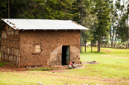 OMO, ETHIOPIA - SEPTEMBER 19, 2011: Unidentified Ethiopian girl near a house. People in Ethiopia suffer of poverty due to the unstable situationのeditorial素材