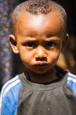 OMO VALLEY, ETHIOPIA - SEP 20, 2011: Unidentified Ethiopian serious little boy in Ethiopia, Sep.20, 2011. People in Ethiopia suffer of poverty due to the unstable situationのeditorial素材