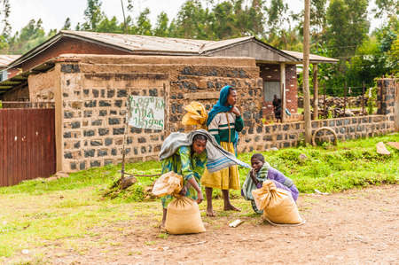 OMO, ETHIOPIA - SEPTEMBER 19, 2011: Unidentified Ethiopian women near a house with bags. People in Ethiopia suffer of poverty due to the unstable situationのeditorial素材