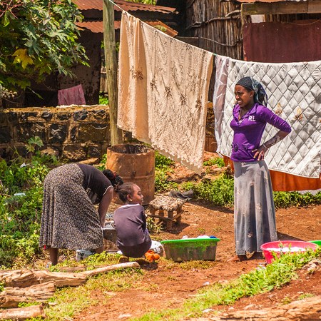 OMO, ETHIOPIA - SEPTEMBER 19, 2011: Unidentified Ethiopian woman hangs clothes. People in Ethiopia suffer of poverty due to the unstable situationのeditorial素材