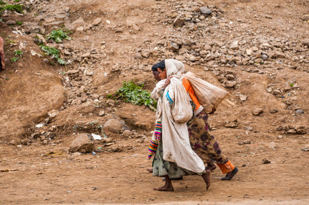 OMO, ETHIOPIA - SEPTEMBER 21, 2011: Unidentified Ethiopian woman with bags in the street. People in Ethiopia suffer of poverty due to the unstable situationのeditorial素材