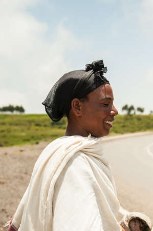 OMO, ETHIOPIA - SEPTEMBER 19, 2011: Unidentified Ethiopian smiling walks by the road. People in...