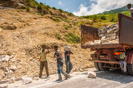 OMO, ETHIOPIA - SEPTEMBER 19, 2011: Unidentified Ethiopian boysput stones in the truck. People in Ethiopia suffer of poverty due to the unstable situationのeditorial素材