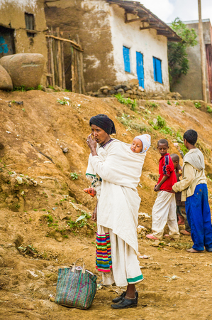 OMO, ETHIOPIA - SEPTEMBER 21, 2011: Unidentified Ethiopian woman with a baby on her back.  People in Ethiopia suffer of poverty due to the unstable situationのeditorial素材