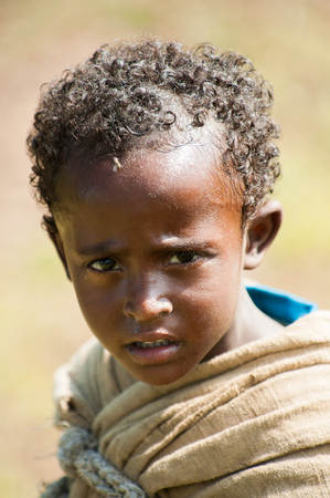 OMO VALLEY, ETHIOPIA - SEP 20, 2011: Unidentified Ethiopian little boy in Ethiopia, Sep.20, 2011. People in Ethiopia suffer of poverty due to the unstable situationのeditorial素材