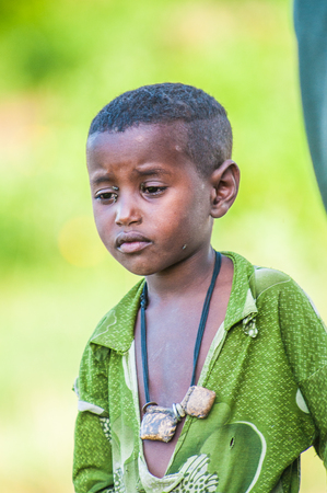 OMO, ETHIOPIA - SEPTEMBER 19, 2011: Unidentified Ethiopian boy with flies on his face. People in Ethiopia suffer of poverty due to the unstable situationのeditorial素材