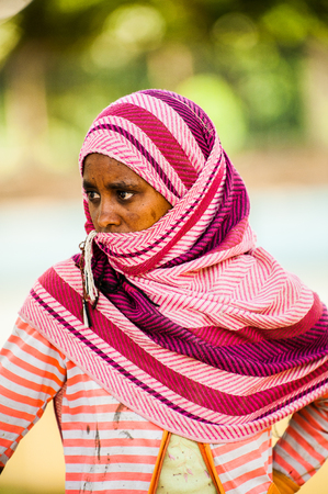 AKSUM, ETHIOPIA - SEPTEMBER 24, 2011: Unidentified Ethiopian woman wears tissue and shuts her face. People in Ethiopia suffer of poverty due to the unstable situationのeditorial素材
