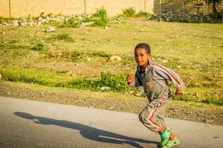 OMO, ETHIOPIA - SEPTEMBER 21, 2011: Unidentified Ethiopian boy runs in the street. People in Ethiopia suffer of poverty due to the unstable situationのeditorial素材