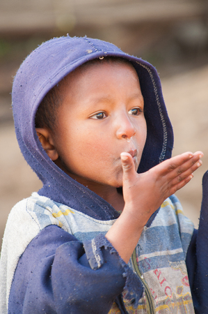 AKSUM, ETHIOPIA - SEPTEMBER 22, 2011: Unidentified Ethiopian boy in front of the camera. People in Ethiopia suffer of poverty due to the unstable situationのeditorial素材