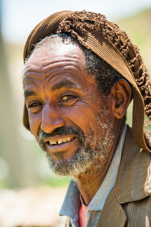 AKSUM, ETHIOPIA - SEP 24, 2011: Unidentified Ethiopian old man in a hat smiles in Ethiopia, Sep.24, 2011. People in Ethiopia suffer of poverty due to the unstable situationのeditorial素材