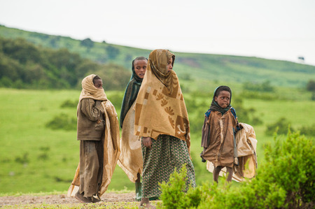 AKSUM, ETHIOPIA - SEPTEMBER 22, 2011: Unidentified Ethiopian children walk with the natural background. People in Ethiopia suffer of poverty due to the unstable situationのeditorial素材