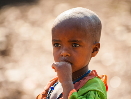 AKSUM, ETHIOPIA - SEP 24, 2011: Unidentified Ethiopian little girl in bright national dress in Ethiopia, Sep.24, 2011. Children in Ethiopia suffer of poverty due to the unstable situationのeditorial素材