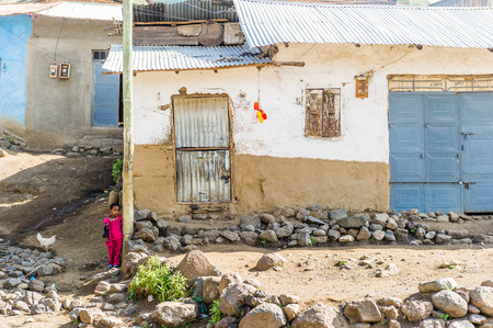 OMO, ETHIOPIA - SEPTEMBER 21, 2011: Unidentified Ethiopian girl near the house. People in Ethiopia suffer of poverty due to the unstable situationのeditorial素材