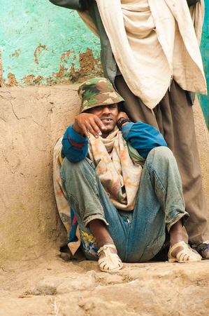 OMO, ETHIOPIA - SEPTEMBER 22, 2011: Unidentified Ethiopian man sits in the street. People in...